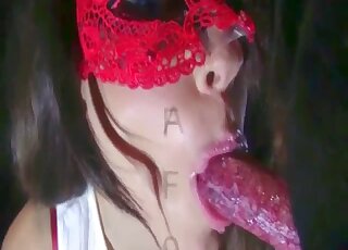 فتاة مقنعة تداعب كلب لابرادور أسود قبل ممارسة الجنس مع الحيوانات